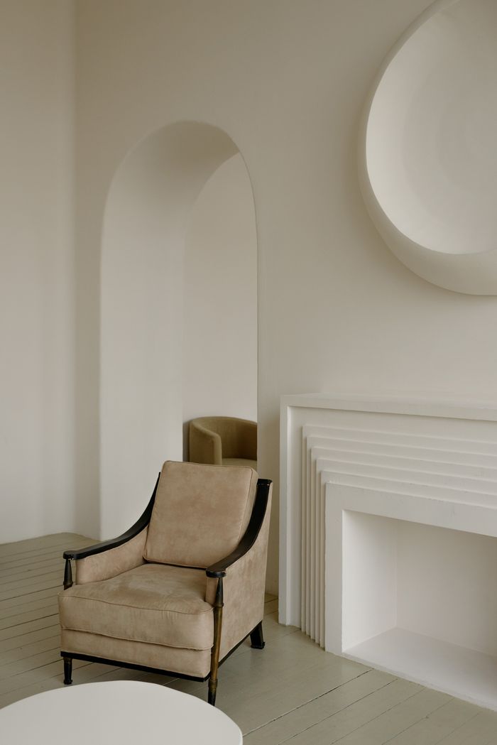 creative-03 Elegant modern interior featuring a beige armchair and minimalist design elements.